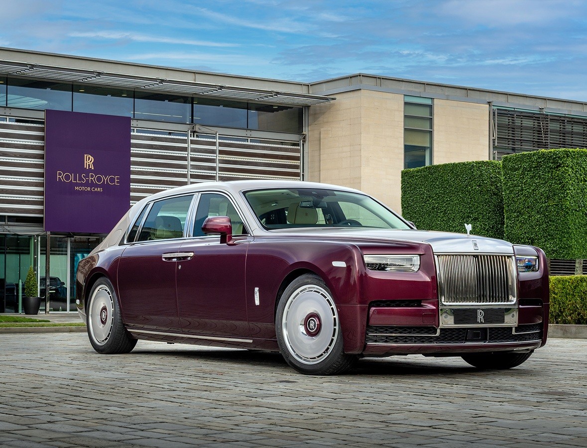 Rolls-Royce binası önünde bordo ve açık renkli Phantom otomobili.