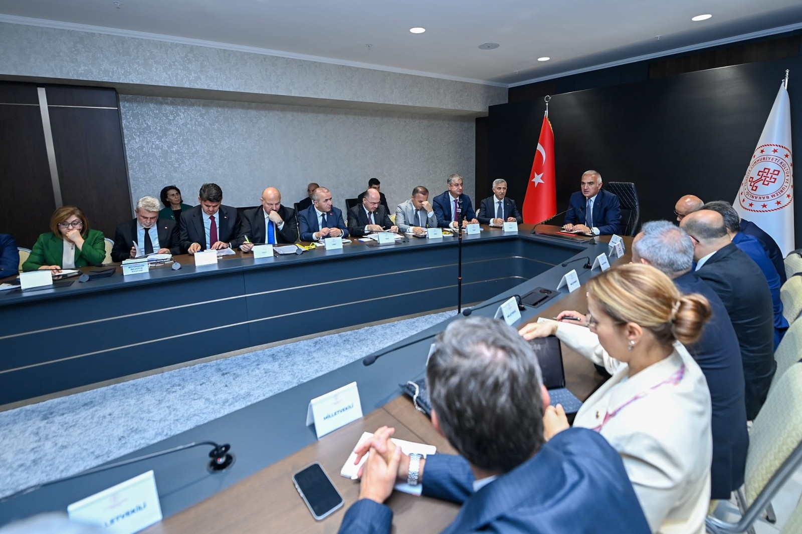 Bayraklı toplantı salonunda heyet masanın iki yanında görüşüyor.