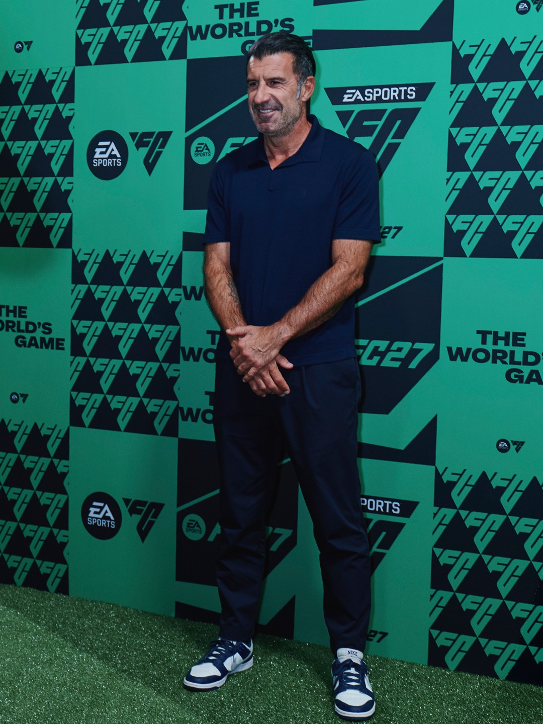 EA SPORTS FC panosu önünde yetişkin katılımcının tam boy portresi.