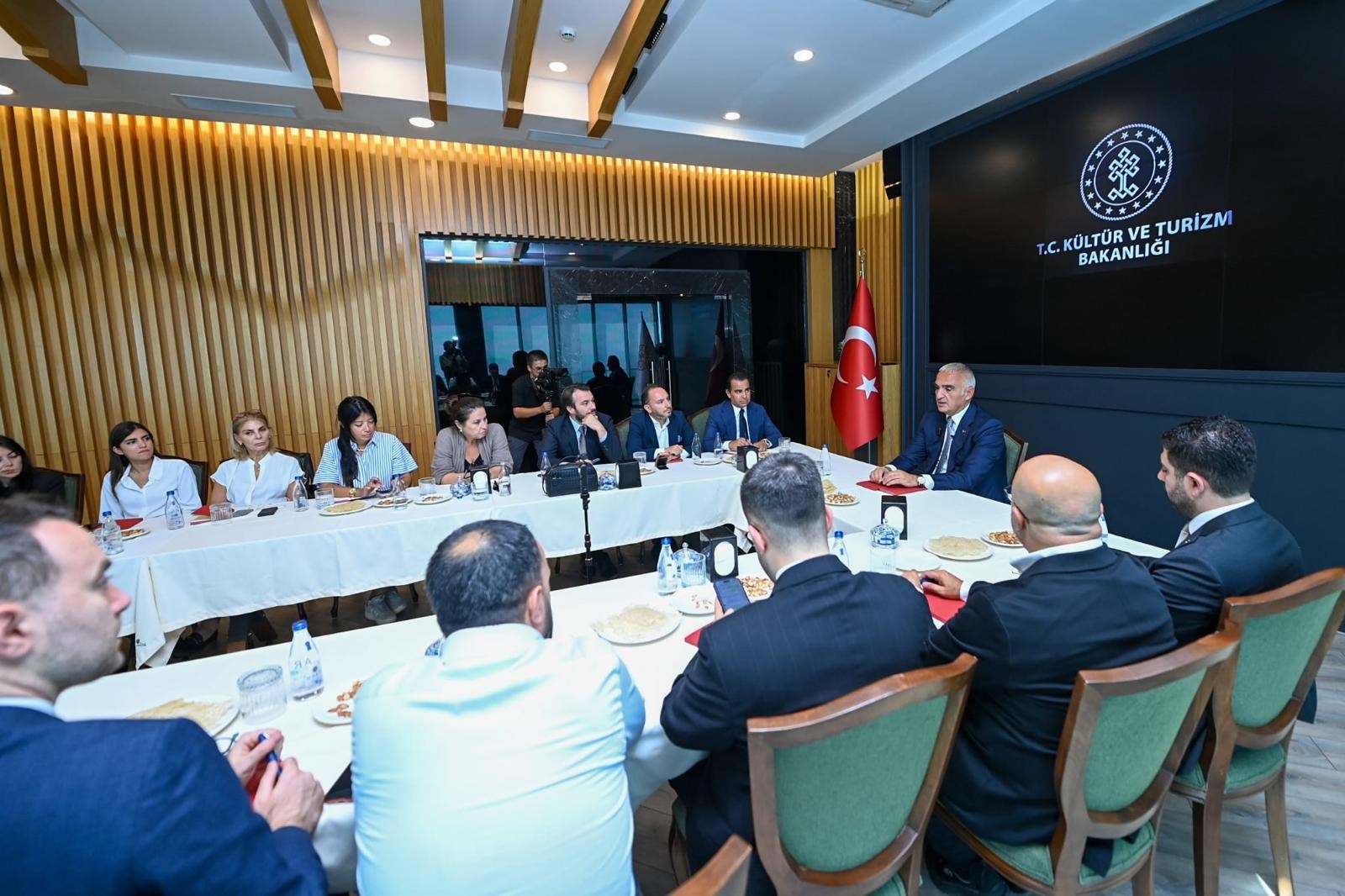 Bakanlık toplantısında konuşmacıyı dinleyen yetişkin katılımcılar.
