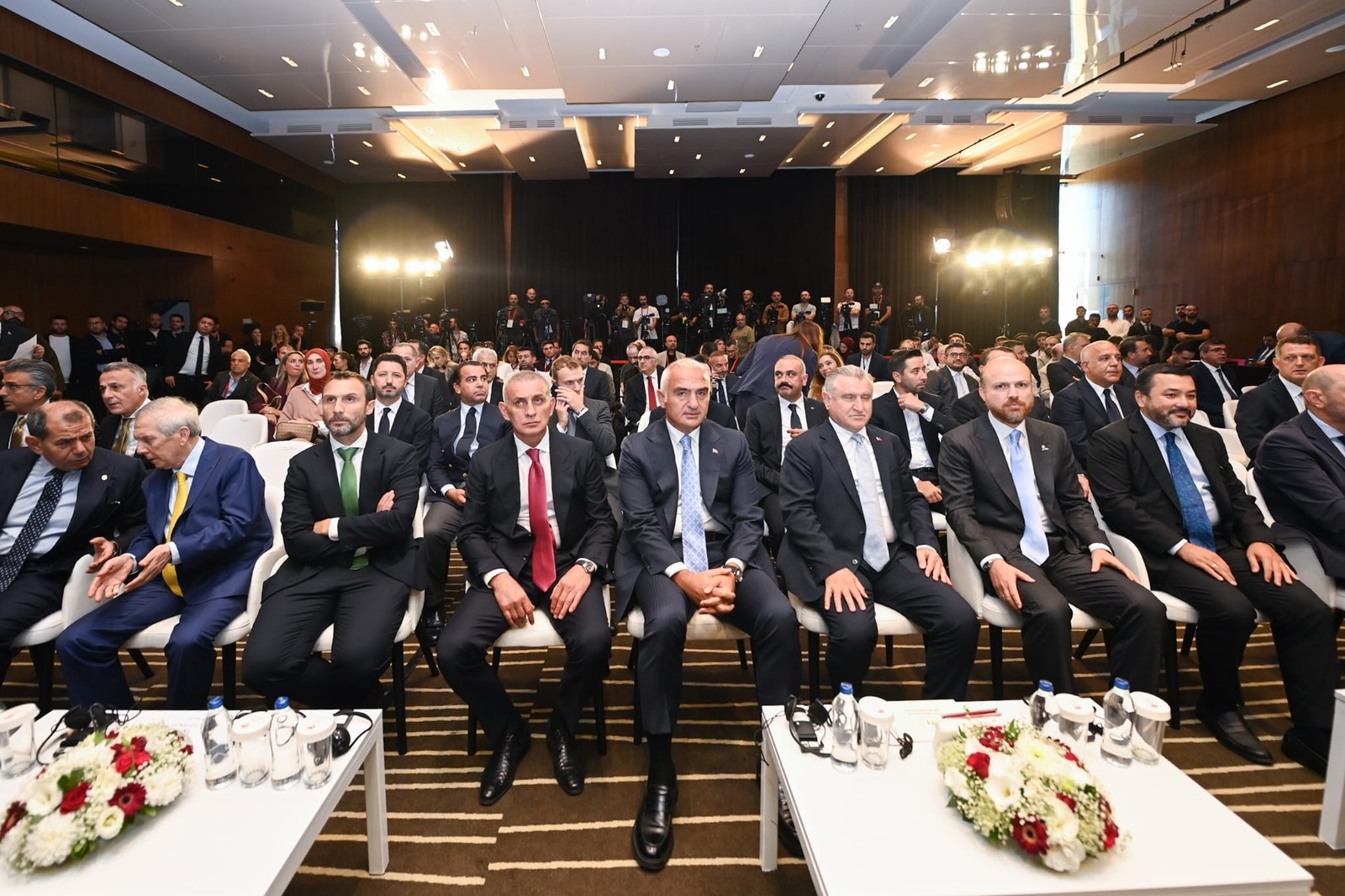 Spor etkinliği duyurusunun ön sıralarında oturan yetişkin katılımcılar.