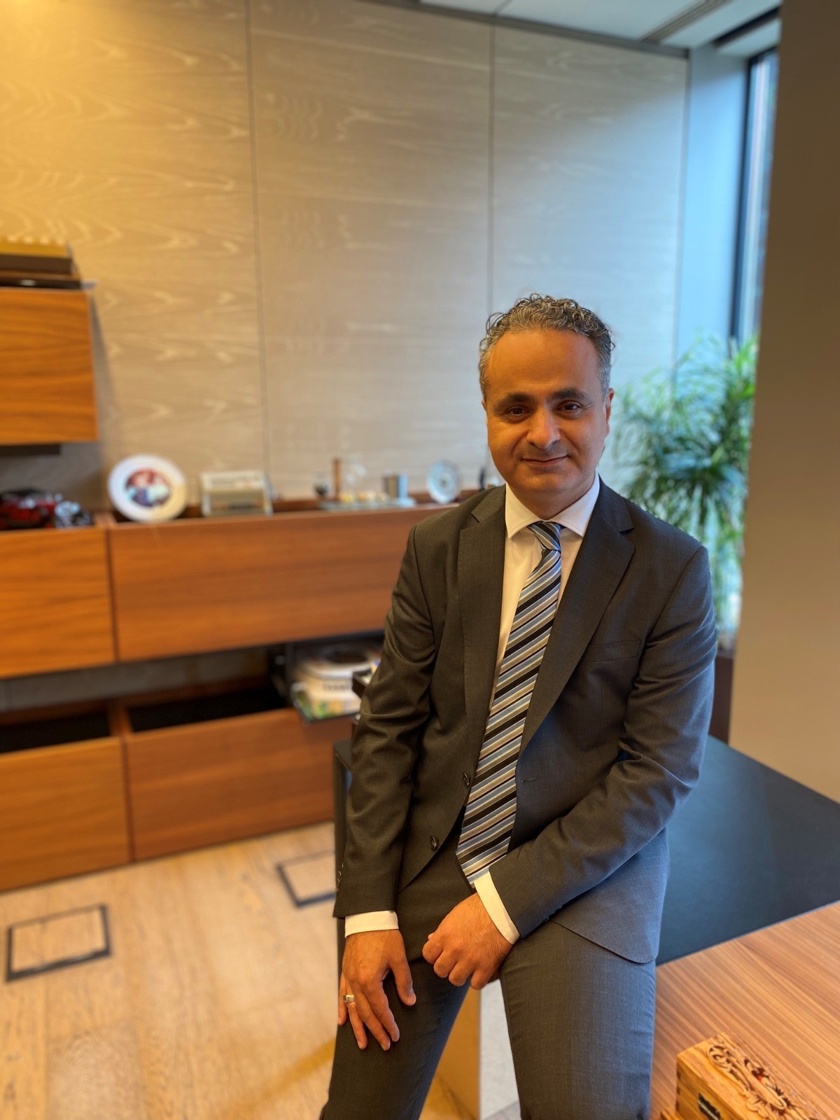 Ofiste çizgili kravatlı Eti Bakır temsilcisinin tam boy portresi.