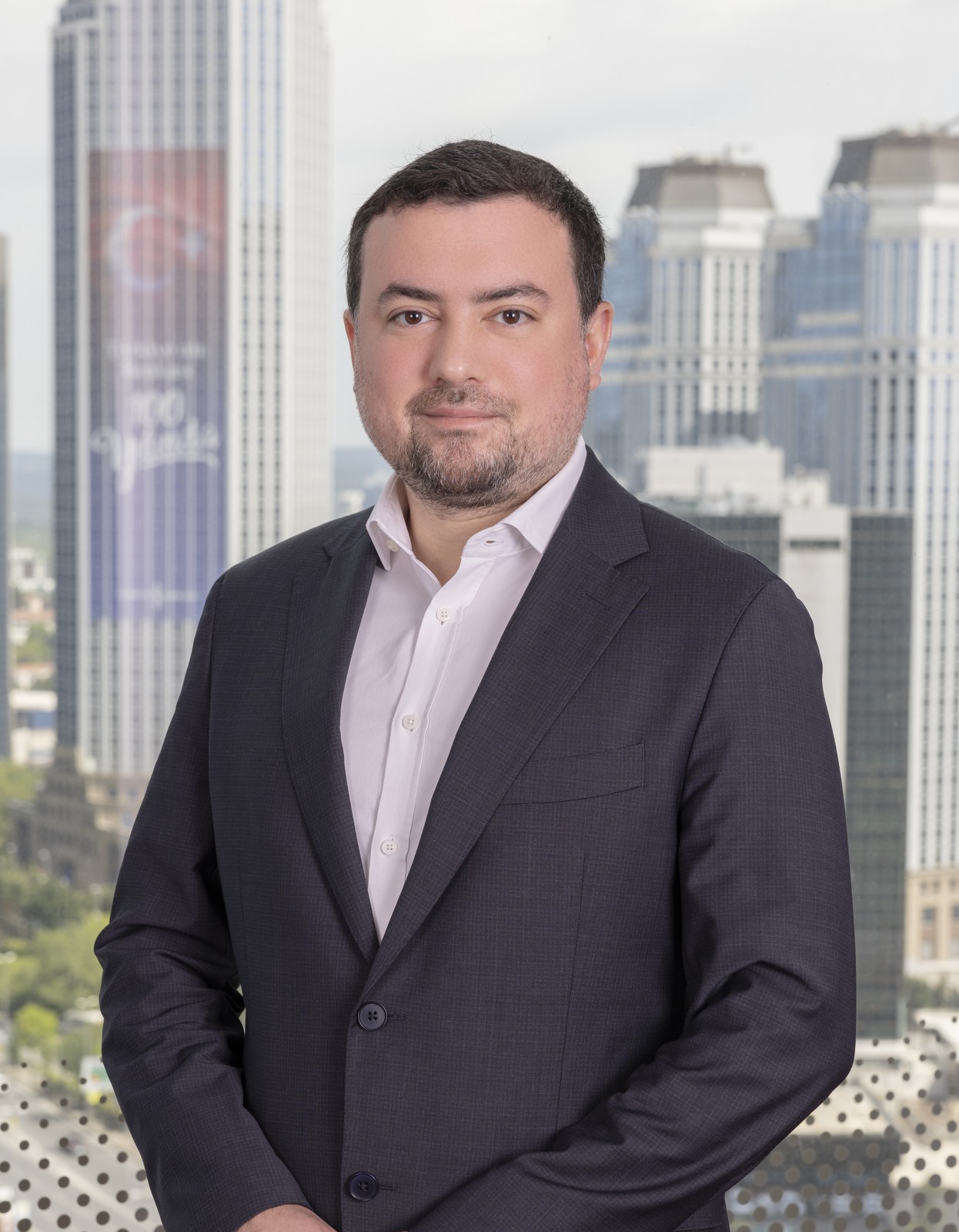 Yüksek binalar önünde koyu ceketli BCG temsilcisinin portresi.