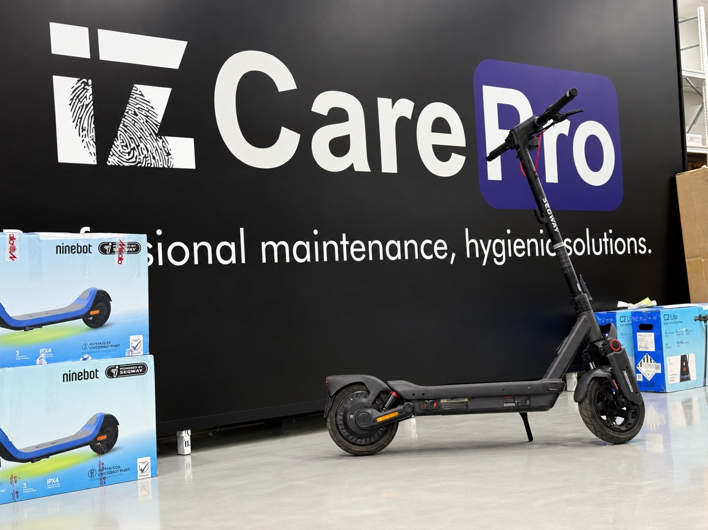 İz CarePro panosu önünde siyah Segway scooter ve kutuları görülüyor.