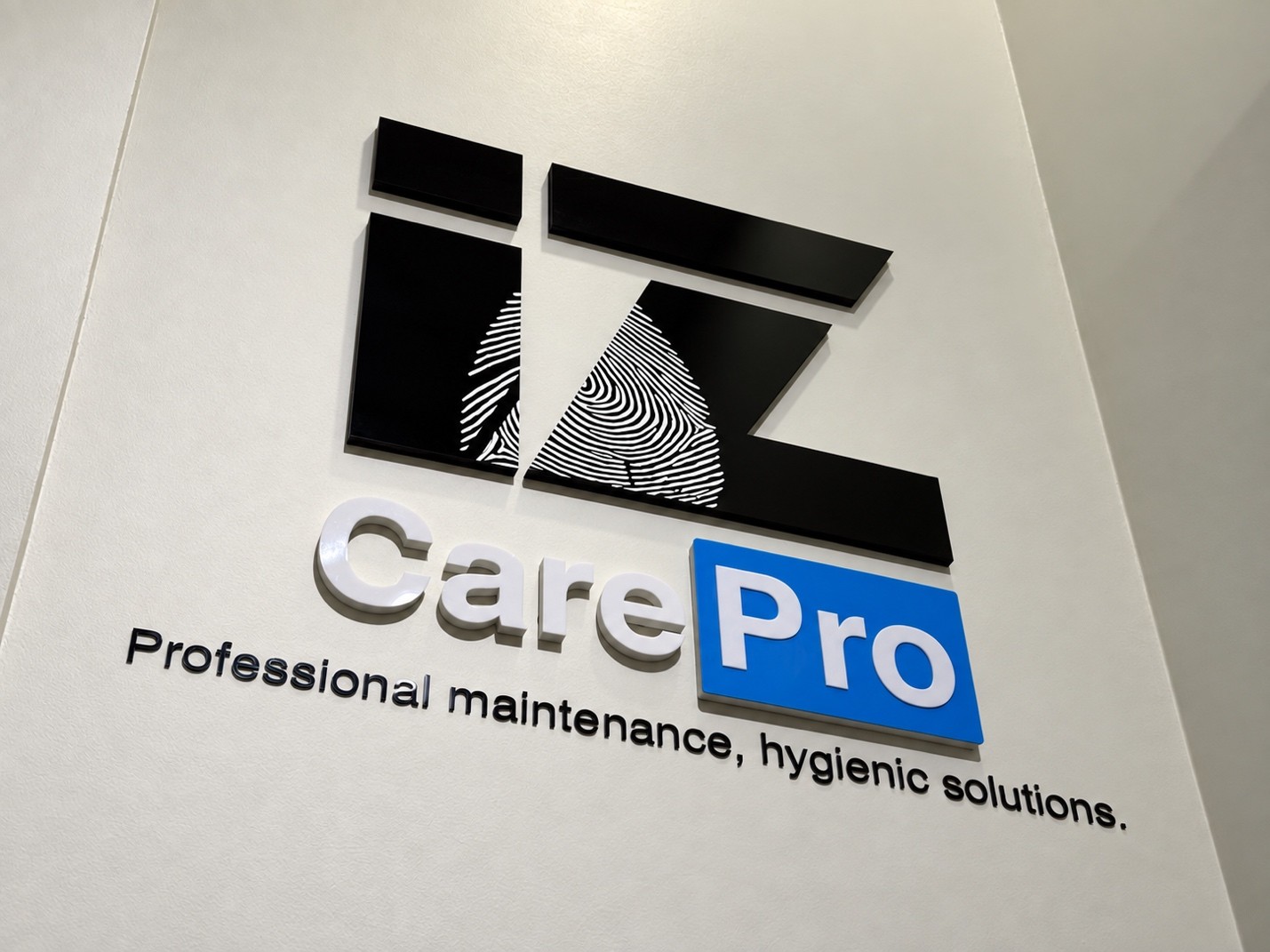 Açılı kadrajda duvardaki İz CarePro logosu ve bakım sloganı görülüyor.