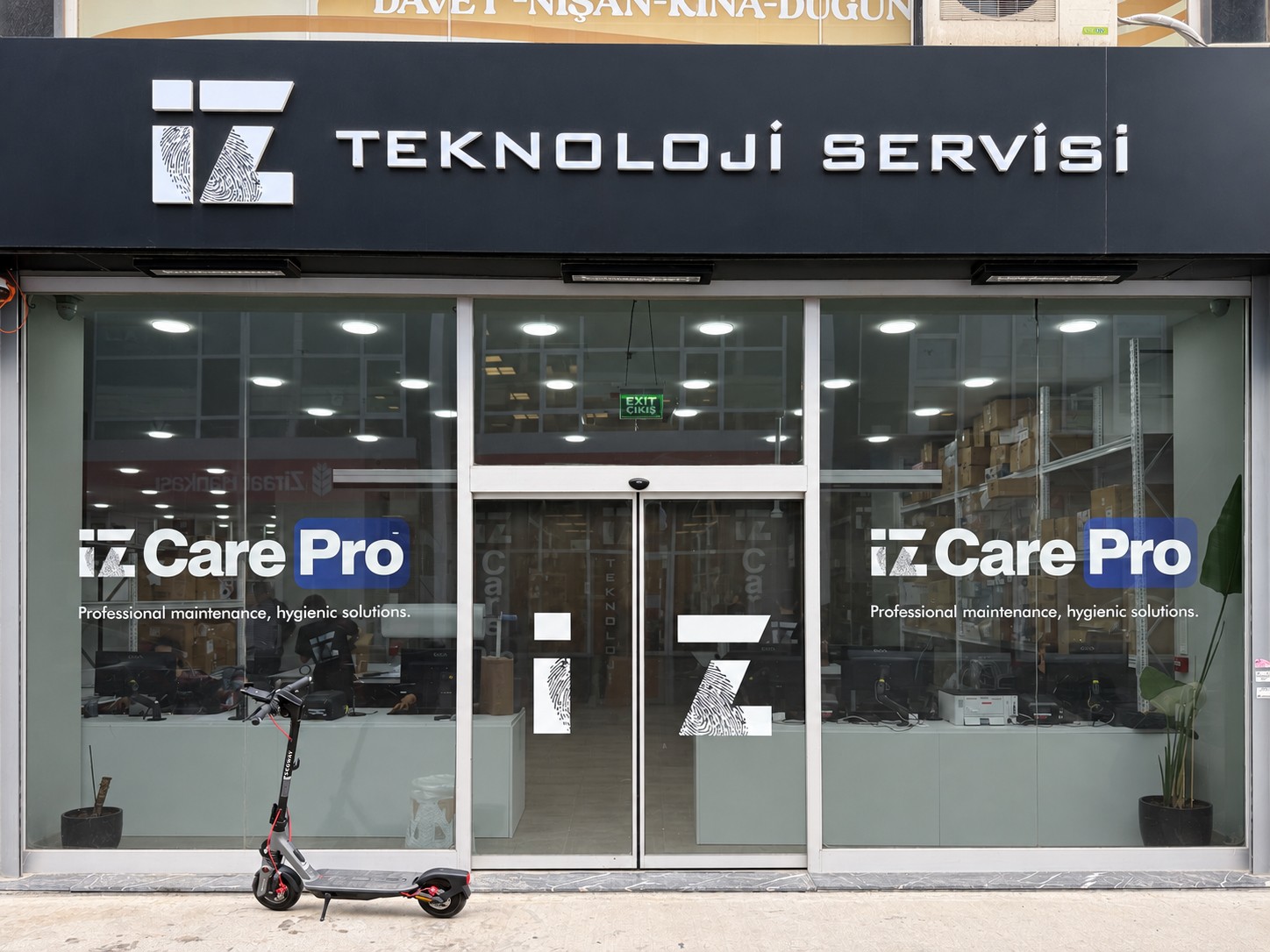 İz Teknoloji Servisi girişinde elektrikli scooter ve servis tabelası.